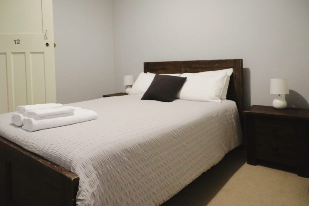 A comfortable double bed showcasing accommodation options at Royal Capertee Hotel